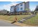 Beautiful modern home featuring stone retaining wall, manicured lawn, and paved steps to the front door at 4232 Edgewood Ct, Marietta, GA 30068
