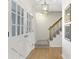 Bright entryway with hardwood floors, staircase, white french doors, and stylish light fixture at 520 Willeo Rd, Roswell, GA 30075