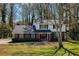 Charming two-story home with brick facade, a well-manicured lawn, mature trees and dark shutters at 520 Willeo Rd, Roswell, GA 30075
