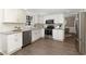 Modern kitchen with white cabinets, granite countertops, stainless steel appliances, and wood-look floors at 520 Willeo Rd, Roswell, GA 30075