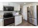 Modern kitchen featuring stainless steel appliances, white cabinets, and granite countertops offers plenty of cooking space at 520 Willeo Rd, Roswell, GA 30075