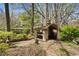 Backyard featuring a stone structure with statues surrounded by lush greenery and mature trees at 1716 Rogers Sw Ave, Atlanta, GA 30310