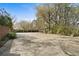 Wide paved driveway leading to a home with brick and stone accents, surrounded by trees and greenery at 1716 Rogers Sw Ave, Atlanta, GA 30310