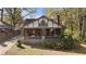 Quaint two-story home with brick and stone accents, complemented by mature trees and greenery at 1716 Rogers Sw Ave, Atlanta, GA 30310