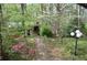Landscaped backyard featuring an outdoor stone structure, brick pathway, and mature landscaping at 1716 Rogers Sw Ave, Atlanta, GA 30310