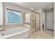 Bright bathroom with a soaking tub, glass-enclosed shower, and tile flooring at 3218 Garden Hill Ln, Douglasville, GA 30135