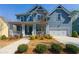 Charming two-story home featuring a covered front porch, a well-manicured lawn, and an attached two-car garage at 3218 Garden Hill Ln, Douglasville, GA 30135
