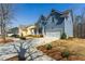 Beautifully landscaped home showcasing an inviting driveway and a two-car garage with lush greenery at 3218 Garden Hill Ln, Douglasville, GA 30135