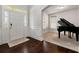 Bright foyer showcasing hardwood floors, white trim, and an adjacent room with a grand piano, perfect for welcoming guests at 3218 Garden Hill Ln, Douglasville, GA 30135