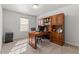 Home office with a built-in wooden desk and shelving with natural light from window at 3218 Garden Hill Ln, Douglasville, GA 30135