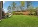 Spacious backyard with lush green lawn, mature trees, and a playset for outdoor enjoyment at 406 Dunaway Ct, Grayson, GA 30017
