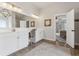 Bathroom featuring a double vanity, modern lighting, and neutral paint palette with a glimpse of the living spaces at 406 Dunaway Ct, Grayson, GA 30017