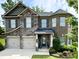 Beautiful two-story home featuring a two-car garage, stone and brick accents, and a manicured lawn at 406 Dunaway Ct, Grayson, GA 30017