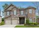 A two-story home with a stone and brick exterior, two-car garage, and landscaped front yard at 406 Dunaway Ct, Grayson, GA 30017