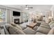 Open concept living room with a fireplace, tv, a comfortable sectional, and hardwood floors at 406 Dunaway Ct, Grayson, GA 30017