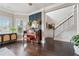 Elegant living space featuring a piano, decorative wall paneling, hardwood floors, and natural light from the large windows at 406 Dunaway Ct, Grayson, GA 30017