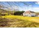 Expansive backyard with a two-story white home and plenty of green space and mature trees at 859 Pownal Ln, Hampton, GA 30228