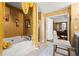 Bright bathroom featuring a standalone tub, stone floors and a door to the main bedroom at 859 Pownal Ln, Hampton, GA 30228