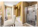 Bright bathroom featuring a glass-enclosed shower, a standalone tub, and a sunny window at 859 Pownal Ln, Hampton, GA 30228