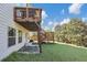 Spacious backyard with lush lawn, mature trees, and a wooden deck with stairs at 5386 Bluestone Cir, Mableton, GA 30126