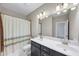 Bathroom features double sink vanity, large mirror, shower with decorative curtain, and tile accents at 5386 Bluestone Cir, Mableton, GA 30126
