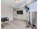 Neutral bedroom with a flat-screen TV, carpeted floor, and black and gold accent chair at 5386 Bluestone Cir, Mableton, GA 30126