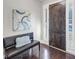 Elegant entryway with dark wood door, hardwood floors, and bench seating underneath decorative art at 5386 Bluestone Cir, Mableton, GA 30126