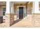 Brick front porch with white columns, brick facade and accent lighting creating a welcoming entrance at 5386 Bluestone Cir, Mableton, GA 30126