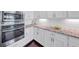 Kitchen boasts stainless steel oven and microwave along with white cabinets and patterned granite countertops at 5386 Bluestone Cir, Mableton, GA 30126