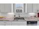 Close up view of stainless steel double sink under window surrounded by white cabinets and granite countertops at 5386 Bluestone Cir, Mableton, GA 30126