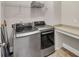 Modern laundry room with stainless steel appliances, countertop space, and overhead storage at 5386 Bluestone Cir, Mableton, GA 30126