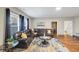 Cozy living room featuring hardwood floors, a comfortable leather sofa, and large windows at 5386 Bluestone Cir, Mableton, GA 30126
