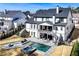 A luxurious backyard featuring a modern pool, spa, and cozy seating area with a fireplace at 109 Owens Mill Pl, Canton, GA 30115