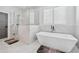 Bright bathroom featuring a modern soaking tub, glass enclosed shower, and white marble tile at 109 Owens Mill Pl, Canton, GA 30115