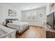 Cozy bedroom with hardwood floors, neutral paint, a comfortable queen-sized bed, and natural light at 109 Owens Mill Pl, Canton, GA 30115