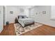 Bright bedroom featuring hardwood floors, neutral paint, a comfortable queen-sized bed, and bright windows at 109 Owens Mill Pl, Canton, GA 30115