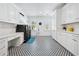 Bright laundry room with black washer/dryer, custom cabinets, ample countertop space and decorative patterned floor tiles at 109 Owens Mill Pl, Canton, GA 30115