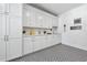 Charming laundry room with white cabinetry, countertops, decorative signs and stylish patterned floor tiles at 109 Owens Mill Pl, Canton, GA 30115