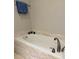 Bright bathroom featuring a soaking tub with travertine surround, modern fixtures and updated faucet at 507 Madison Se Ct, Smyrna, GA 30080