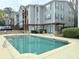 Community pool with sun deck, lounge chairs and grilling area with surrounding apartments and greenery at 507 Madison Se Ct, Smyrna, GA 30080