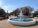 Fountain at Smyrna Market Village, surrounded by well-maintained landscaping, retail spaces, and a bright blue sky at 507 Madison Se Ct, Smyrna, GA 30080