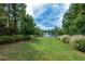 Expansive backyard with lush lawn sloping down to a scenic lakefront view at 722 Laurel Canyon Pkwy, Canton, GA 30114