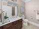 This bathroom features dark wood cabinets, a white sink, and neutral wall and floor tiles at 722 Laurel Canyon Pkwy, Canton, GA 30114