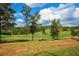 Picturesque golf course featuring vibrant green grass and a golf cart on a sunny day at 722 Laurel Canyon Pkwy, Canton, GA 30114