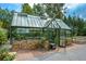Charming greenhouse with glass panels, brick foundation, and thriving plants inside at 722 Laurel Canyon Pkwy, Canton, GA 30114