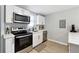 Bright kitchen featuring stainless steel appliances, white cabinets, and light hardwood floors at 119 Old Vandiver Dr, Canton, GA 30114