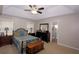 Cozy bedroom with a tray ceiling, ceiling fan, and view to the bathroom at 2562 Kennesaw Springs Nw Ct, Kennesaw, GA 30144
