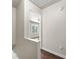 Hallway with hardwood floors and a view into a bright room with a large window at 2970 Aspen Woods Entry, Atlanta, GA 30360