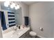 Well-lit bathroom features a vanity with white countertop and modern fixtures and blue and white striped shower curtain at 3132 Meadowstone Sw Ln, Atlanta, GA 30331