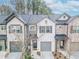 A view of charming townhomes with a well-manicured lawn, gray garage doors, and professionally landscaped lawns at 3132 Meadowstone Sw Ln, Atlanta, GA 30331